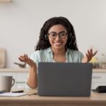 Online teacher working from home, using a laptop and headphones for a video call.