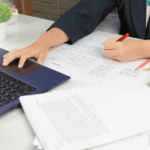 woman working on laptop and proofreading documents from home