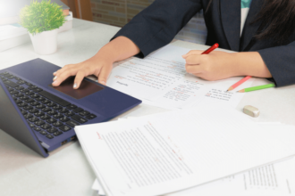 woman working on laptop and proofreading documents from home