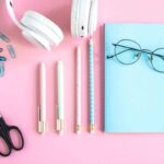 Still life of freelancer's desk with headphones, notepad, and other home office accessories.