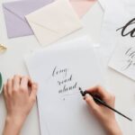 Woman handwriting calligraphy on stationary at home