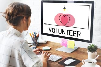 A woman volunteering virtually from a computer in her home office.